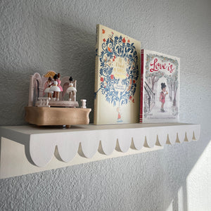 scalloped shelf with books and music box